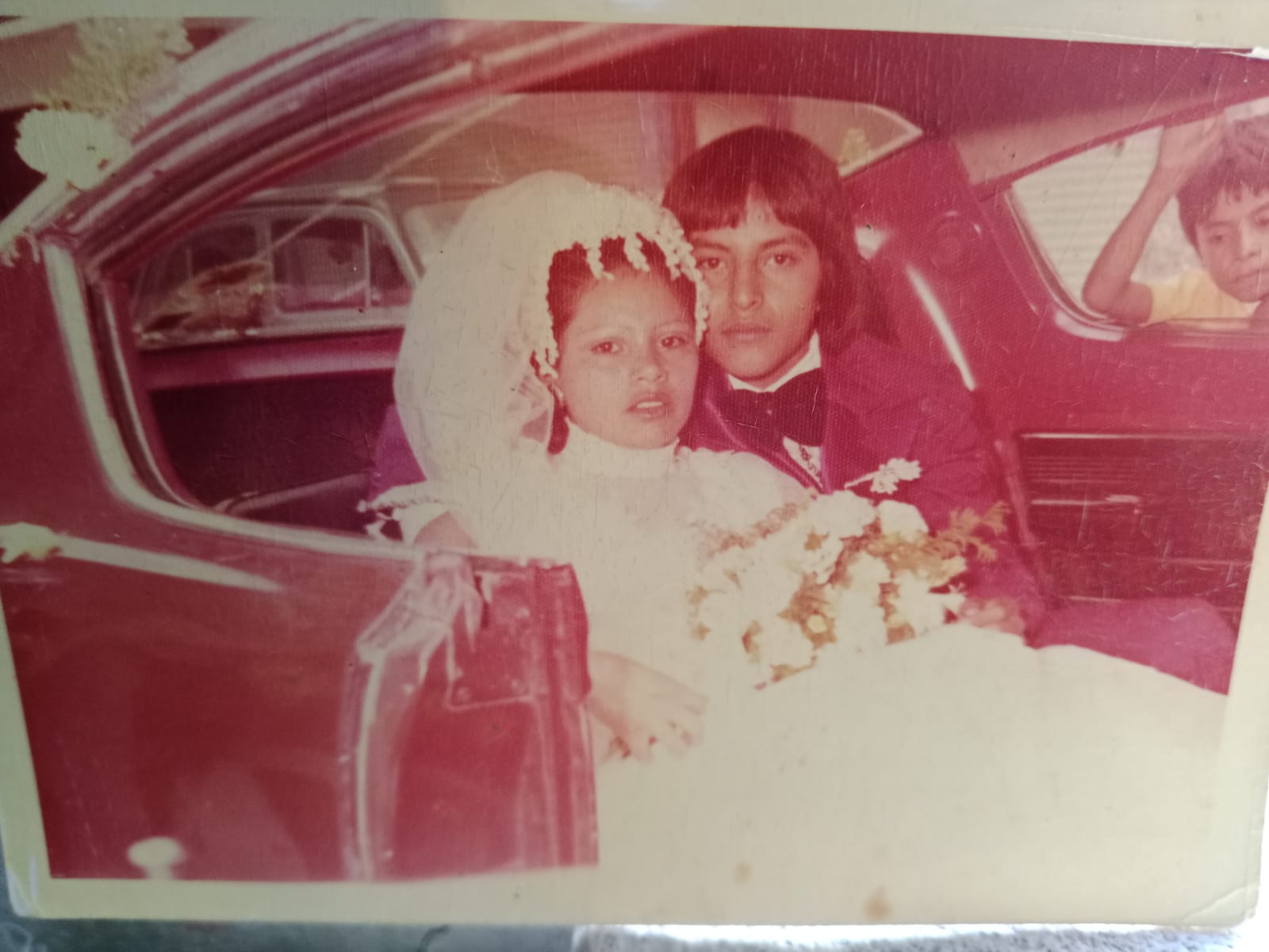 Elena y Ricardo recién casados junto a un automóvil